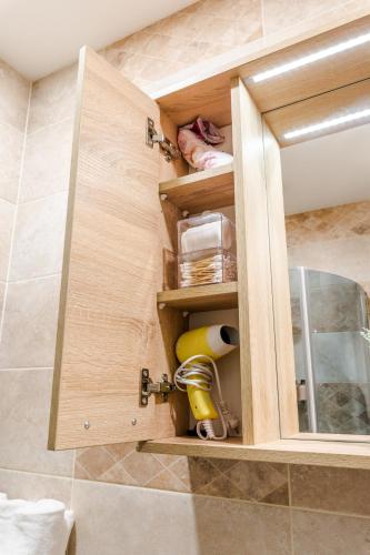 a bathroom with a wooden cabinet with a sink at Tallinna mnt 2, Apartment 3 in Haapsalu