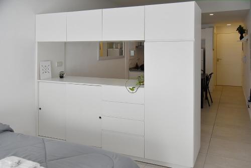 a white cabinet in a room with a bed at Luminosos y modernos departamentos en Rosario in Rosario