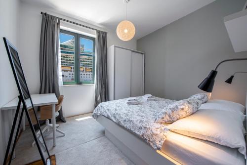 杜布羅夫尼克的住宿－51街公寓，一间卧室配有一张床、一张书桌和一个窗户。