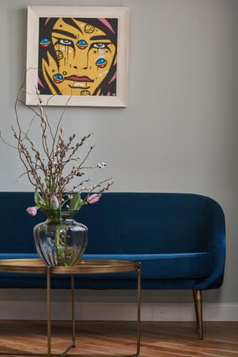 a blue couch with a vase on a table at The Embassy Suites in Sofia
