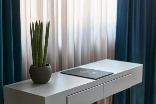 a white table with a plant in a vase on it at The Embassy Suites in Sofia