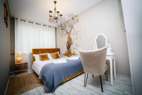 1 dormitorio con cama, silla y escritorio en Exquisite 3 room apartment in the heart of thetown, en Câmpulung Moldovenesc