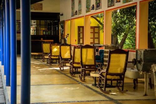 a row of chairs sitting outside of a building at Hotel La Casa de los Árboles Immersive Experience in Zacualpan de Amilpas