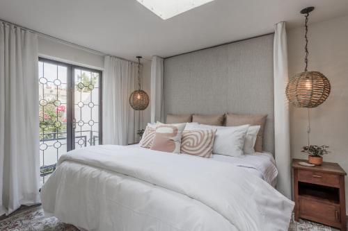 a bedroom with a large white bed and a window at Casa Recreo King Suite Apartments in Centro, San Miguel de Allende in San Miguel de Allende