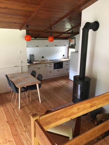a kitchen and dining room with a wood stove at MAJKÓWKA in Łąkie
