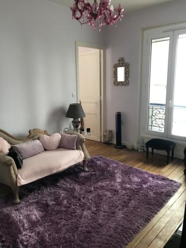 - un salon avec un canapé et un tapis violet dans l'établissement Superbe appartement proche de la butte Montmartre, à Paris