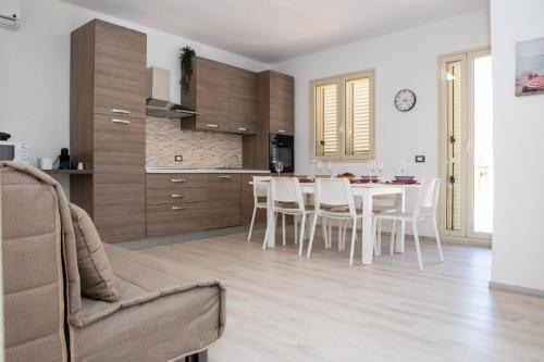 una cucina e una sala da pranzo con tavolo e sedie di Endless Summer Apartment a Marina di Ragusa