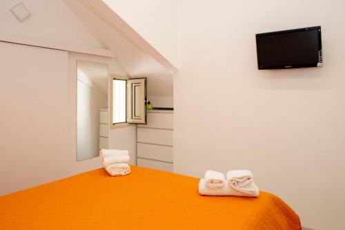 um quarto com duas toalhas numa cama com uma televisão em Endless Summer Apartment em Marina di Ragusa