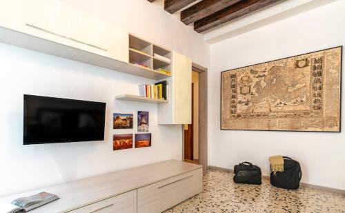 een woonkamer met een flatscreen-tv aan de muur bij Ponte Squero Flat M0270423226 in Venetië