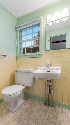 a bathroom with a toilet and a sink and a mirror at Mid-Town Motel in Boothbay Harbor
