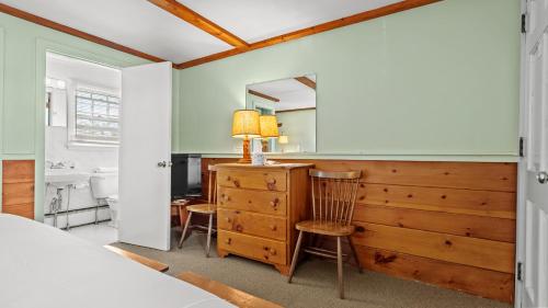 a bedroom with a bed and a dresser and a mirror at Mid-Town Motel in Boothbay Harbor