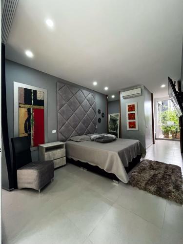a bedroom with a large bed and a chair at CASA LUZ Hospedaje, Pereira , Cerritos in Pereira