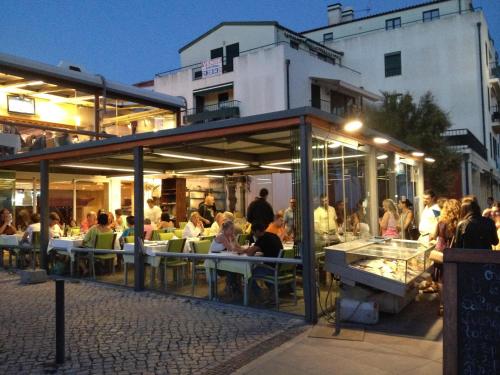 un grupo de personas sentadas fuera de un restaurante en Beach4you - Sesimbra, en Sesimbra