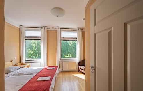 a bedroom with two beds and two windows at Christos Hotel in Söderhamn