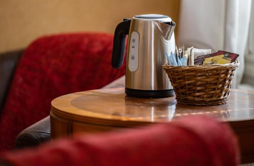eine Kaffeemaschine auf einem Tisch mit einem Korb darauf in der Unterkunft Christos Hotel in Söderhamn