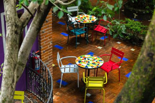 a group of tables and chairs on a brick patio at Hotel La Casa de los Árboles Immersive Experience in Zacualpan de Amilpas