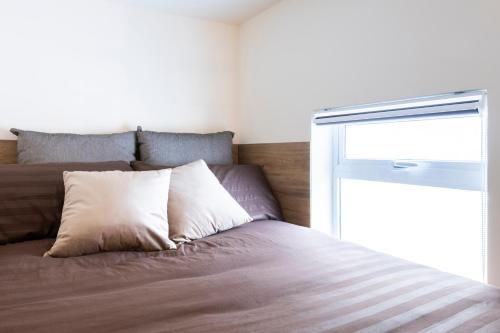 a bed with a pillow and a window in a room at 248 Boutique Studios, Sliema in Sliema