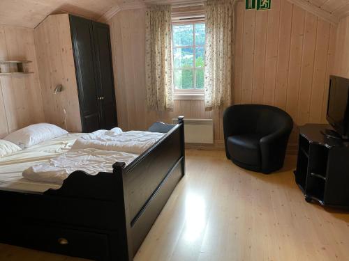 a bedroom with a bed and a chair and a window at Tinden in Hemsedal