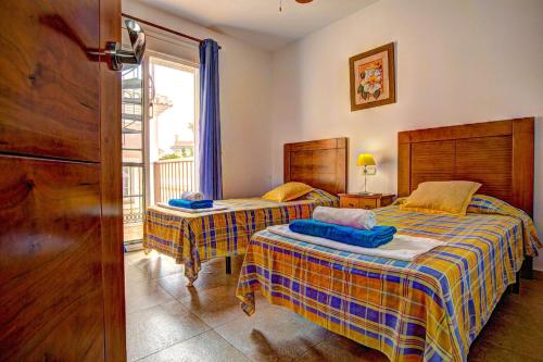 a bedroom with two beds and a window at Villa Reyes in Nerja