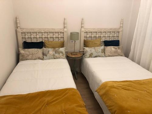 two beds sitting next to each other in a bedroom at La casita de El Montan Baja in Avilés