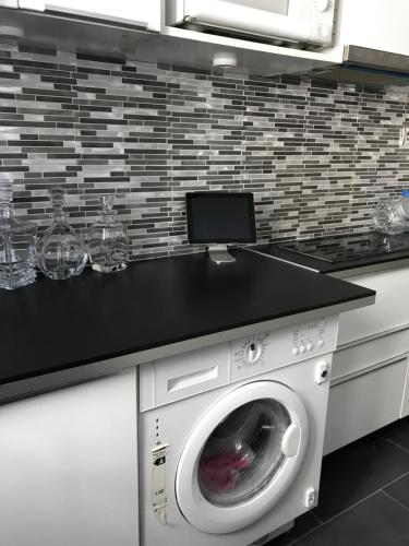 une cuisine avec un lave-linge et un comptoir. dans l'établissement Superbe appartement proche de la butte Montmartre, à Paris