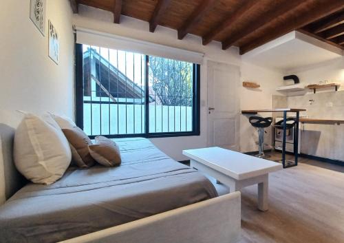 Habitación con cama, mesa y ventana en Caballería de los Andes - Andarlibre en San Martín de los Andes