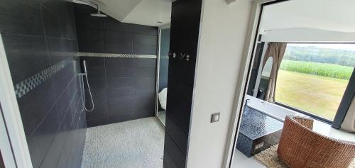 łazienka z prysznicem i szklanymi drzwiami w obiekcie VILLA INATTENDUE w mieście Liffré