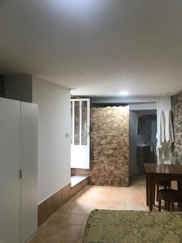 a living room with a table and a stone wall at A Casa de Santos in Combarro