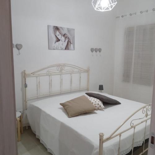 Dormitorio blanco con cama blanca y almohada en Casa Angelina Summer, en Casalabate