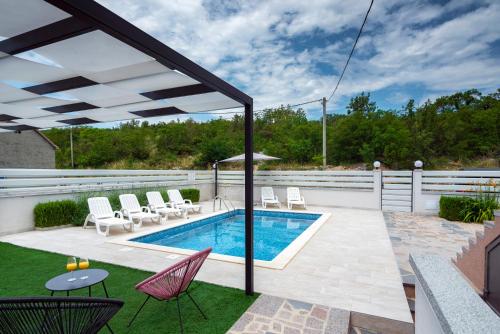 un patio con piscina, sillas y una valla en Luxury with gallery, heated pool only for you-KLIS CRO, en Klis