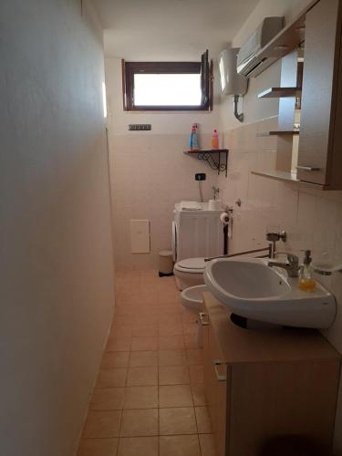baño con 2 aseos, lavamanos y ventana en Casa Vilu' en Paestum