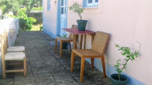 una mesa y dos sillas sentadas junto a una pared en Linhal das Meias - São José das Matas, 