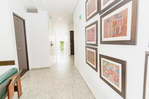 a hallway with framed art on the walls at Hotel Las Molas in Apartadó