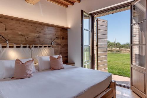 a bedroom with a large bed and a large window at Terra Antica - Resort, Winery & SPA in Montepulciano