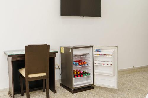 a small refrigerator with its door open next to a table at Hotel Las Molas in Apartadó
