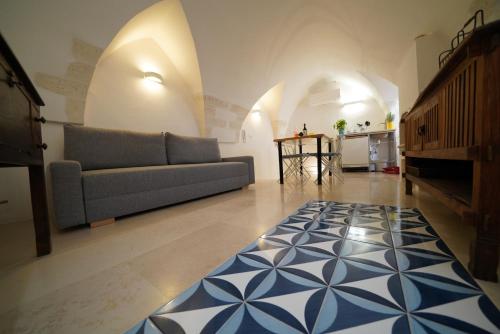 sala de estar con sofá y alfombra azul y blanca en Blu_Cielo Terra, en Ostuni
