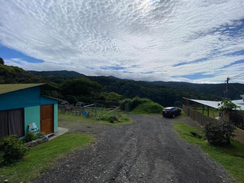 a dirt road with a car parked next to a house at Lidia's Mountain View Vacation Homes in Monteverde Costa Rica