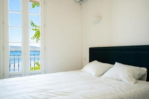 a bedroom with a large bed with a large window at VILLA AMPHITRITE, SAINT TROPEZ in Saint-Tropez