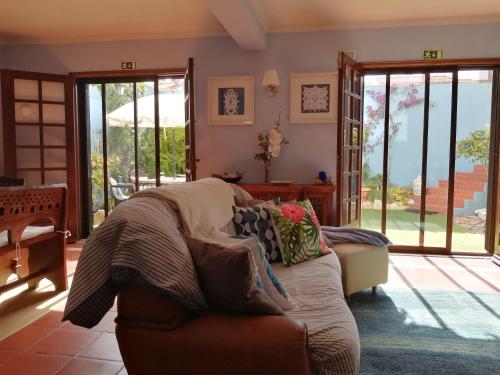 a living room with a couch and sliding glass doors at Peniche Blue Wave Home in Peniche