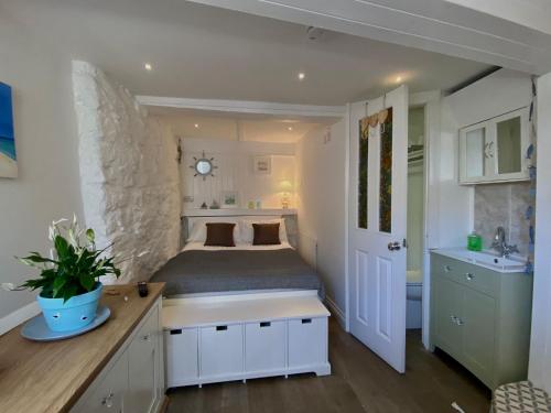 a bedroom with a bed and a sink in it at 3 Bedroom Cottage minutes walk from town, harbour & Beaches. in St Ives