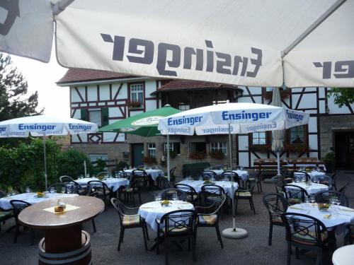 a group of tables with umbrellas in front of a building at Wengerterstube & Gästezimmer Kern in Oberderdingen