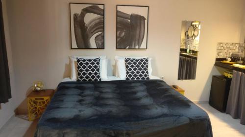 a bedroom with a large bed with four pictures on the wall at Chalé Juliet in Pirenópolis