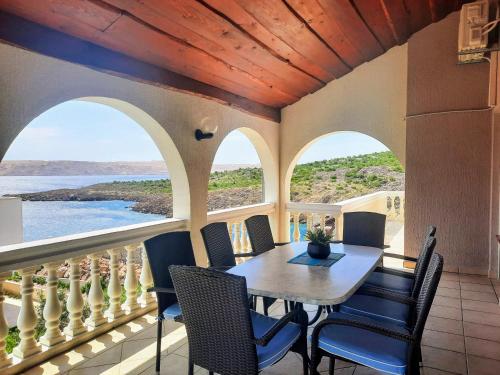 a dining room with a table and chairs on a balcony at Villa Mihaela - Apartment Mario in Cesarica