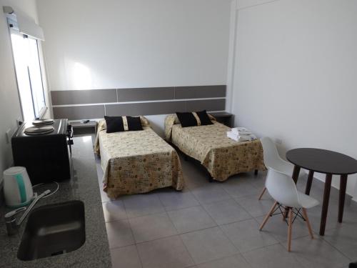 Una habitación con dos camas y una mesa dentro. en Urquiza, en Salta