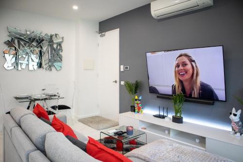 a living room with a couch and a flat screen tv at Soho 1A in Geelong