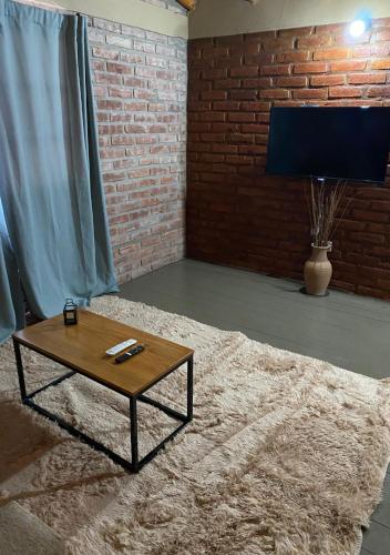 a living room with a coffee table and a brick wall at Cabañas Abigail in Nono