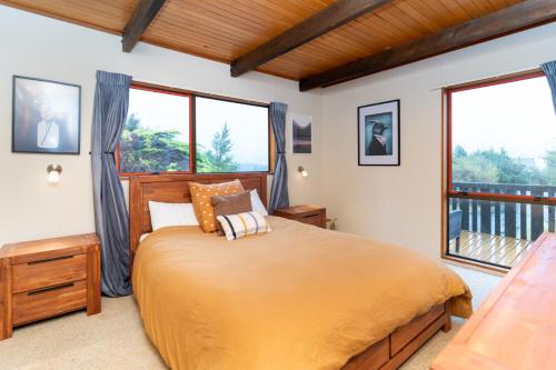 een slaapkamer met een groot bed en ramen bij 42a Alpine Avenue in Hanmer Springs