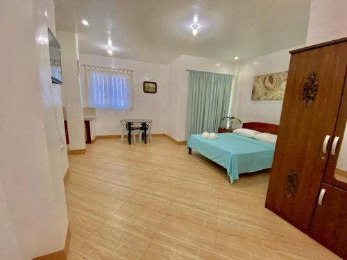 a bedroom with a bed and a table in it at CoombsGuestHouse in Siquijor