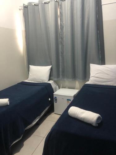 Cette chambre comprend 2 lits et un rideau. dans l'établissement Ágape Hotel, à Rio Verde