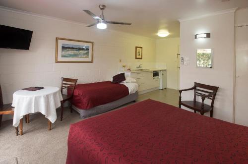 a hotel room with a bed, table and a lamp at Maleny Hills Motel in Maleny